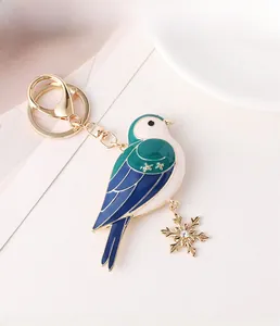 Detail eines blauen Vogel-Schlüsselanhängers mit Goldflocke und Kristallverzierung