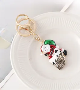 Macro shot of Santa Claus climbing a chimney keychain with red enamel and gold clasp