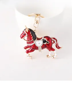 Détail de porte-clés cheval en émail rouge avec strass blancs et métal doré brillant