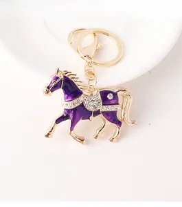 Détail macro du porte-clés cheval en émail violet avec placage d'or et strass brillants