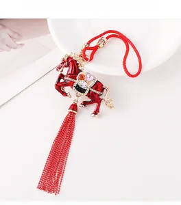 Detail of red enamel horse pendant with crystal rhinestones and long bead tassel