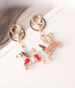 Détail des porte-clés cheval sertis de strass en émail rouge et finitions à taches brunes