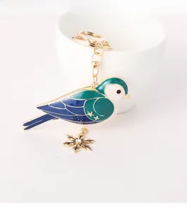 Detailansicht vom Vogel Schlüsselanhänger mit blauem Emaille und Schneeflocken Anhänger