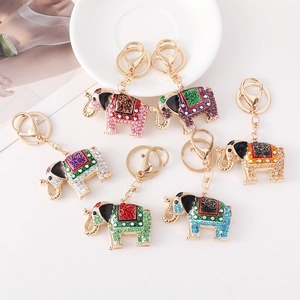 Set of six colorful elephant keychains with crystals and gold-plated finish on white surface