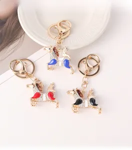 Détail des porte-clés poney ornés de cristaux en émail rouge, bleu et noir brillant