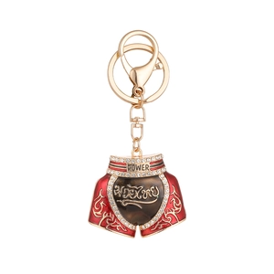 Red Muay Thai shorts keychain with Power text and gold metal buckle on white background