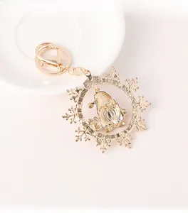 Detail of golden Christmas gnome keychain with snowflake frame on a white ceramic plate