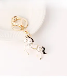 Detailansicht vom weißen Emaille-Pferdeschlüsselanhänger mit Kristallen und Gold-Finish