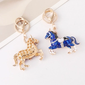 Porte-clés cheval en émail bleu et métal doré avec détails en strass brillants