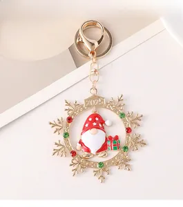 Detail of 2025 Christmas gnome keychain with red and green rhinestones on gold snowflake frame