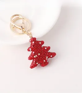Close-up of a Christmas tree keychain with red rhinestones and golden lobster clasp