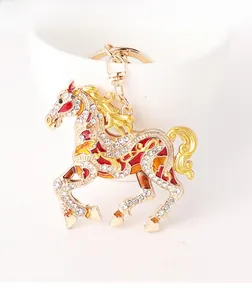 Close-up of golden horse keychain featuring colorful enamel details and crystal rhinestones