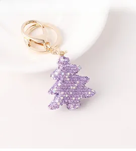 Detail of a purple Christmas tree keychain with sparkling rhinestones and golden clasp