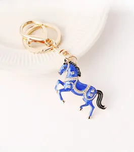 Detailaufnahme eines blauen Emaille-Pferdeanhängers mit Kristallen und goldener Schließe