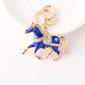 Porte-clés cheval émail bleu avec cristaux brillants et finition dorée sur blanc
