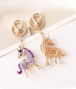 Detail of crystal encrusted purple horse keychain and golden hollow design pendant charms