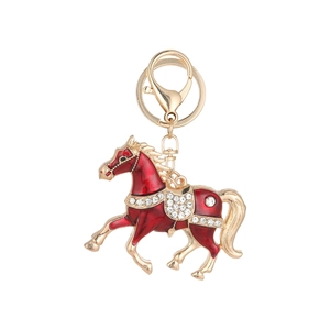 Porte-clés cheval doré avec émail rouge et strass brillants sur fond blanc
