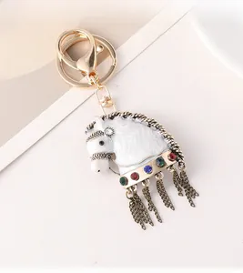 Dettaglio di portachiavi a forma di cavallo vintage con strass e nappe dorate