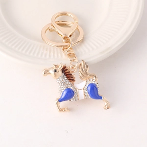 Porte-clés cheval élégant avec émail bleu et strass brillants sur une assiette blanche