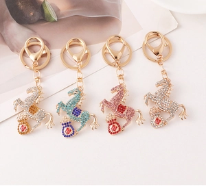 Close-up of rhinestone horse keychains in four colors with lucky red bag charms