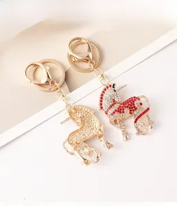Détail des porte-clés licorne avec cristaux rouges et transparents sur alliage doré brillant