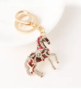 Détail de porte-clés cheval avec émail rouge, strass étincelants et fermoir mousqueton