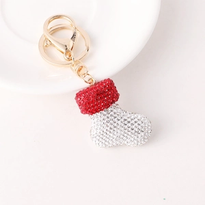 Christmas stocking keychain with red and silver rhinestones on a white ceramic plate