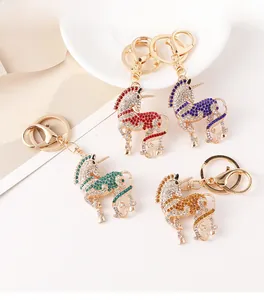Détails de porte-clés licorne en cristal rouge et bleu avec des strass étincelants