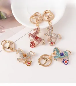 Detail of four horse keychains with crystals and money bag pendants in various colors
