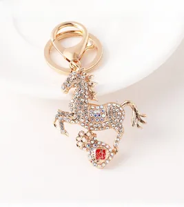 Detailed view of golden horse keychain with sparkling crystals and fortune bag charm
