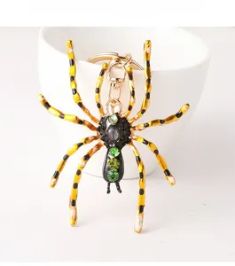 Vue détaillée du porte-clés araignée jaune avec cristaux verts sur une tasse blanche