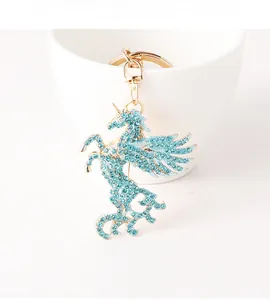 Détail du porte-clés licorne en strass bleu clair brillant sur une tasse en céramique blanche