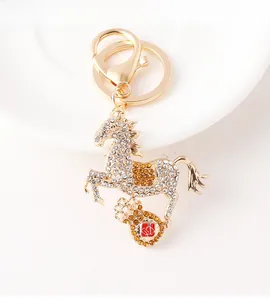 Detail of horse keychain with gold plating, crystal rhinestones and money bag charm