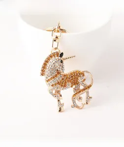 Détails d'un porte-clés licorne dorée orné de cristaux ambrés et blancs brillants