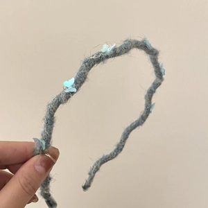 Blue knit headband with butterfly accents for women, stylish winter hair accessory