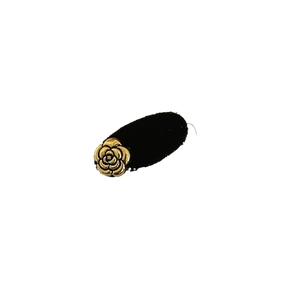 Brown velvet camellia hair clip with a golden metal flower on a minimal white background