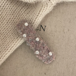 Vintage pink tweed hair clip featuring elegant white pearls on a soft knit background