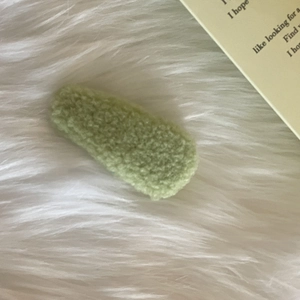 Detailed close-up of grass green plush BB hair clip with soft faux fur texture
