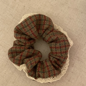 Vintage plaid scrunchie with white lace trim for women on beige fabric background