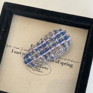 Détail rapproché d'une barrette en tweed français avec texture tricotée multicolore