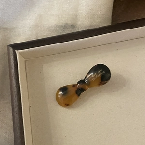 Macro detail of tortoiseshell acetate hair clip with golden Barrette la France logo