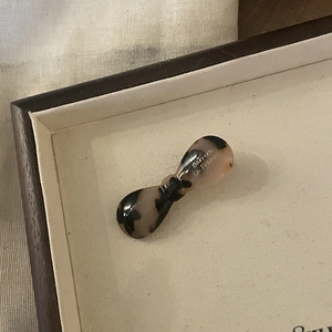 Detailed close-up of tortoise shell bow hair clip with white Barrette La France lettering