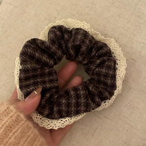 Close-up of vintage plaid scrunchie featuring purple tweed fabric and white lace trim