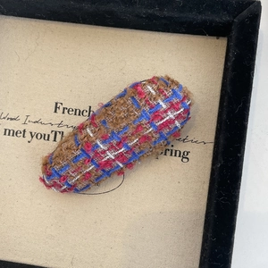 Détail de la pince à cheveux en tweed français avec tissu tissé multicolore marron et bleu