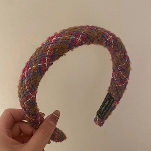 Détail du serre-tête en tweed avec fils argentés et étiquette tissée fait main