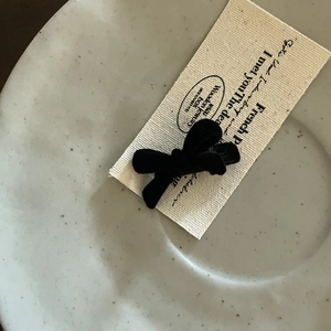 Close-up of black velvet bow hair clip on minimalist card holder for women