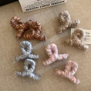 Gros plan de pinces à cheveux en tricot pelucheux aux tons terre et texture douce