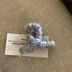 Vue détaillée d'une pince à cheveux en tricot lavande avec texture pelucheuse et douce