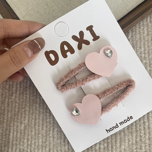Détail de barrettes à cheveux en forme de cœur rose avec strass sur carte de support