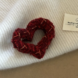 French red heart hair claw with gold stitching on cozy white knit background